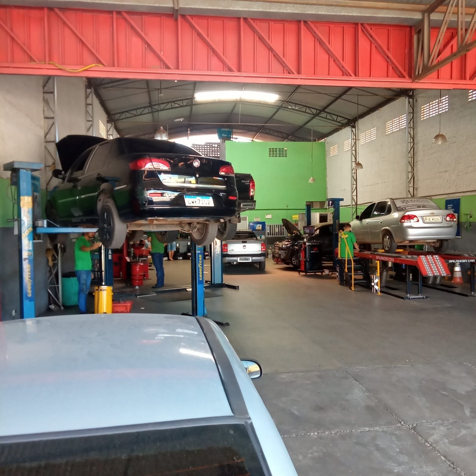 Interior da oficina Murilão Auto Serviços, em Teresina, com veículos nos elevadores